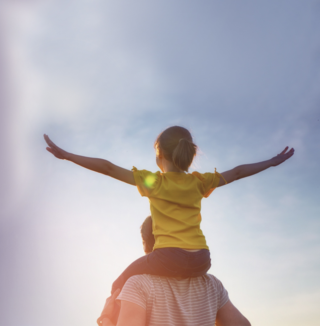 Eine Person trägt ein Mädchen auf den Schultern