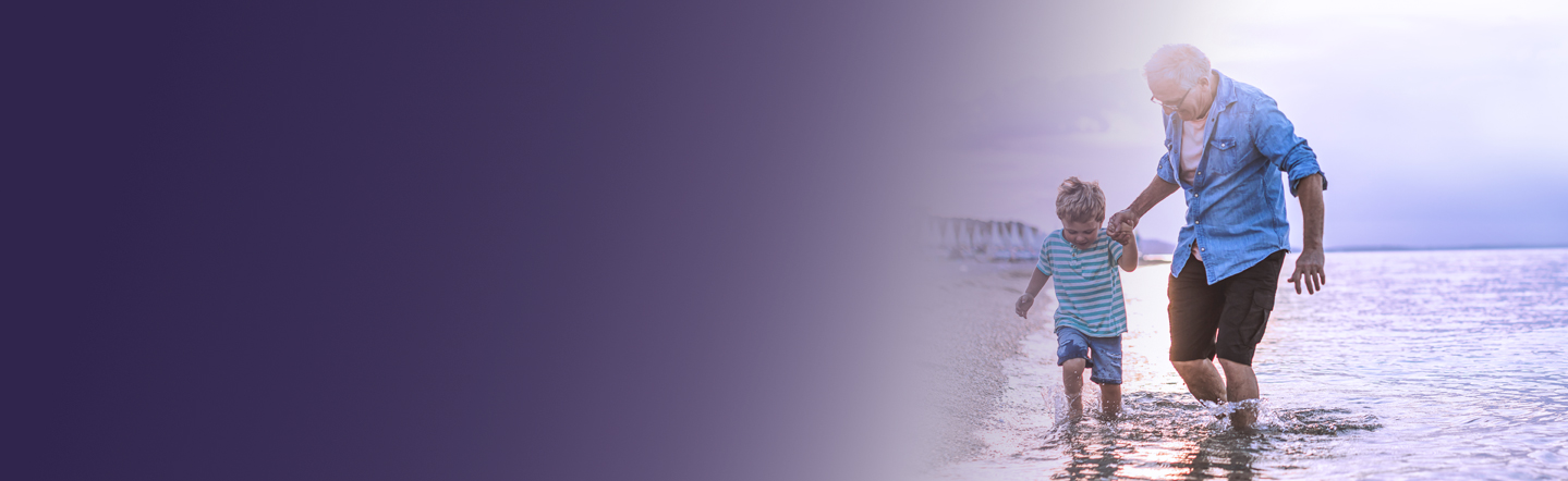 Ein Mann spaziert mit einem Kind am Meer, Hand in Hand